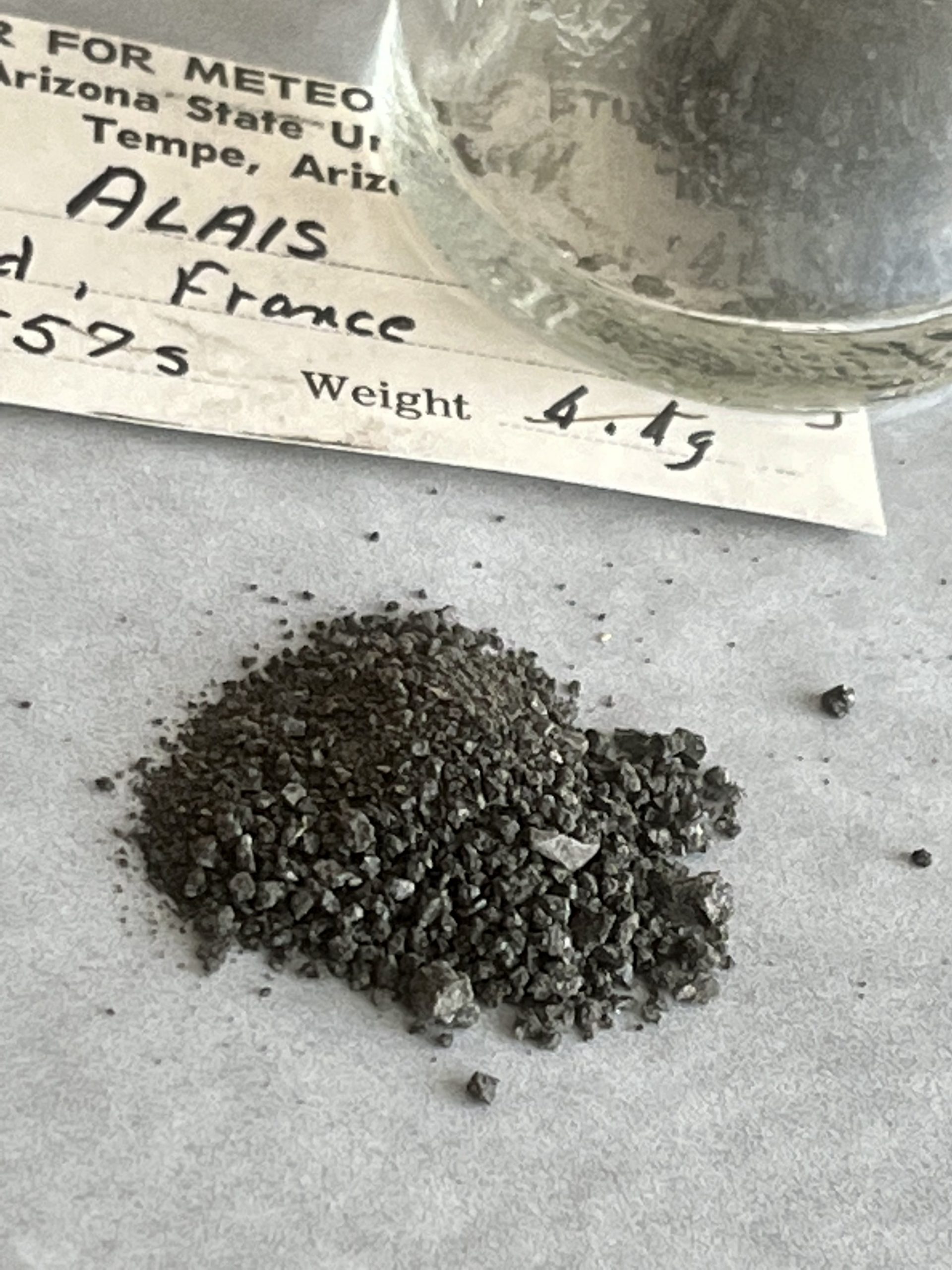 Alais meteorite fragments next to storage jar.